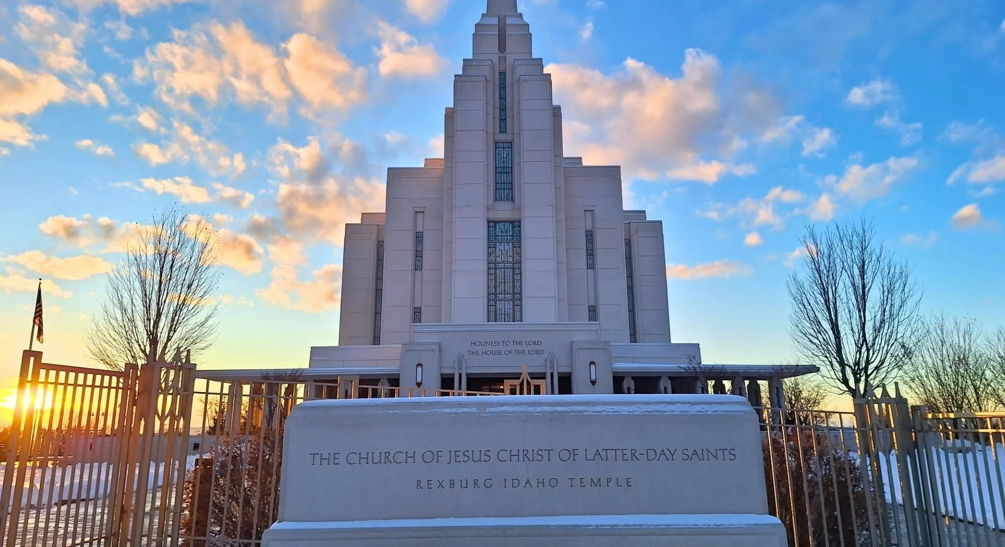 The Rexburg Idaho Temple in golden-hour light under a blue sky full of peach-coloured clouds